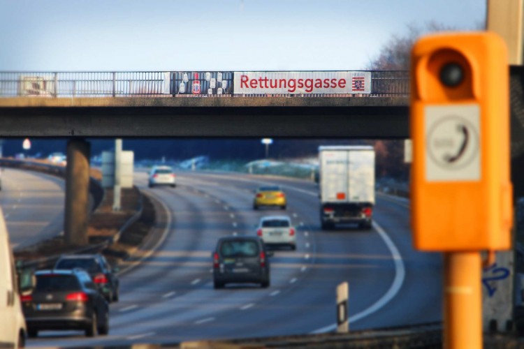 Rettungsgasse-Banner an einer Brücke über der Autobahn