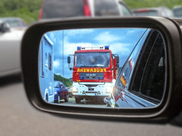 Blick in den Außenspiegel, ein Einsatzfahrzeug nähert sich